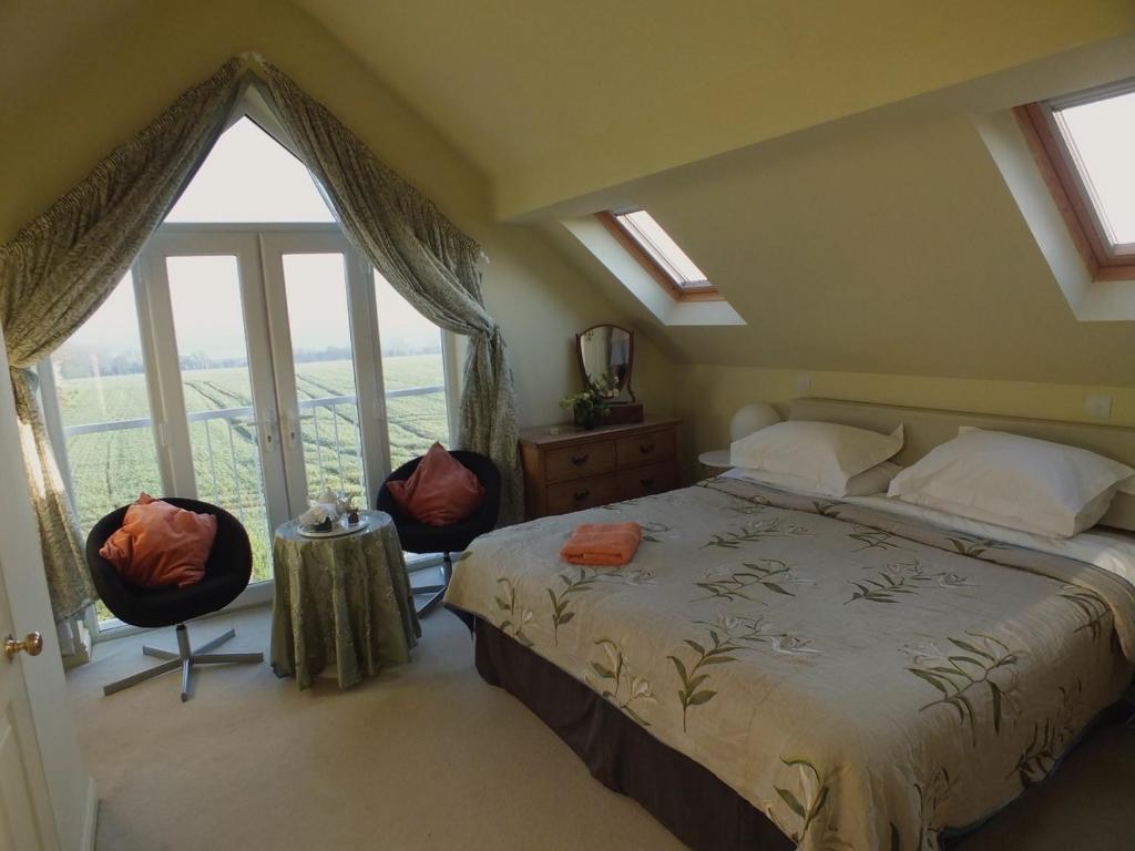 una camera da letto con un letto e una grande finestra di Herb Cottage a Bradford on Avon