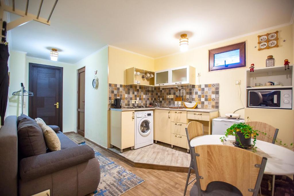 een keuken en een woonkamer met een bank en een tafel bij Apartments Beautiful Tbilisi on L.Meskhishvili Turn 1 in Tbilisi City