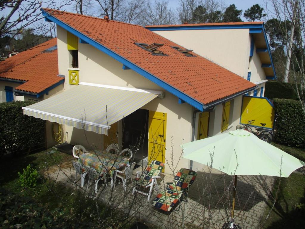 een huis met een tafel en stoelen ervoor bij Elartxo II in Saint-Julien-en-Born