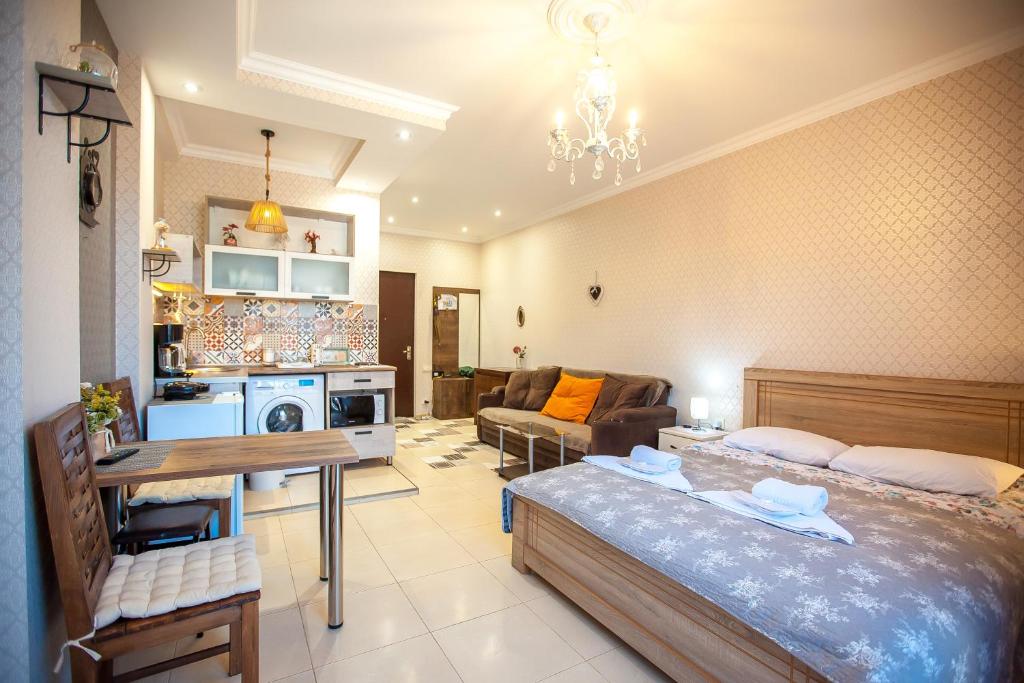 a bedroom with a bed and a living room at Beautiful Tbilisi on Meskhishvili Turn in Tbilisi City