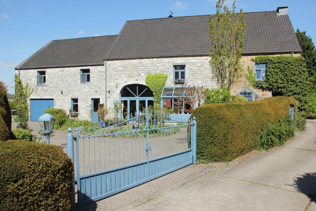 una casa con una valla azul delante de ella en l'Heure bleue en Aywaille