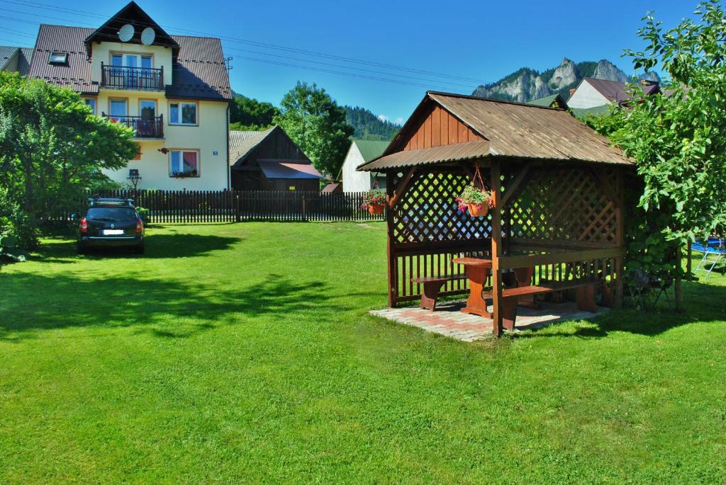 um gazebo de madeira com um banco num quintal em Pokoje u Danusi em Sromowce Niżne