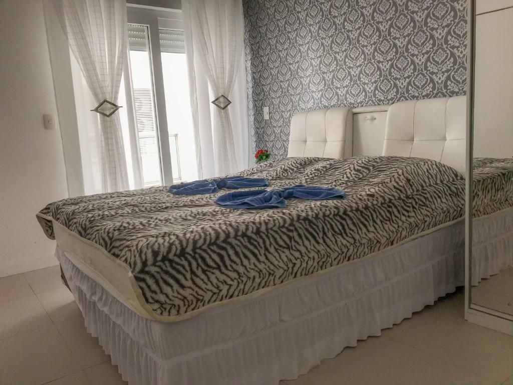 Una cama en un dormitorio con un espejo. en Apartamento Maravilhoso em Florianópolis na Praia dos Ingleses com piscina, en Florianópolis