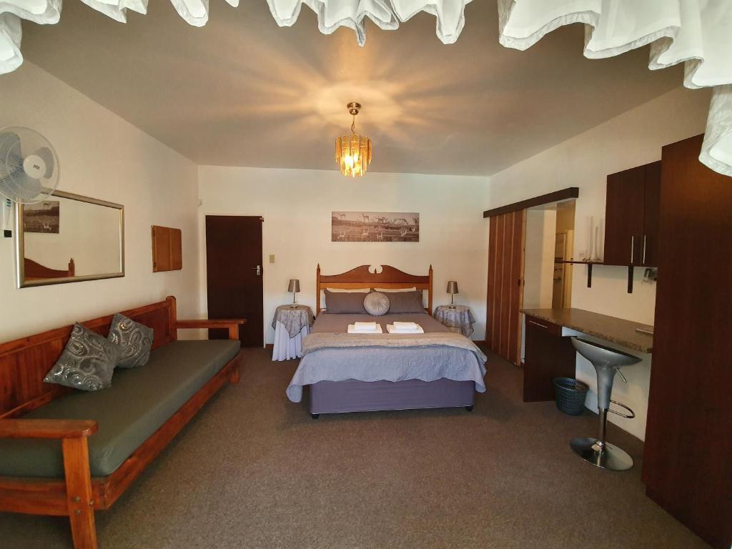 a bedroom with a bed and a desk in it at Karoo View Guesthouse Cradock in Cradock