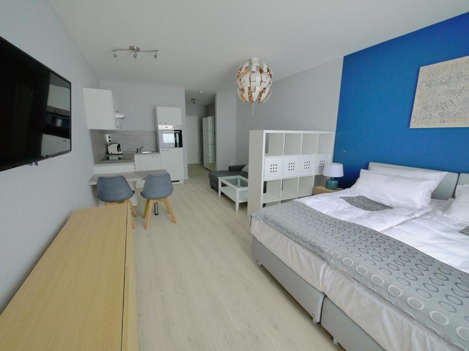 een slaapkamer met een groot bed en een blauwe muur bij Blue River Side in Blaustein