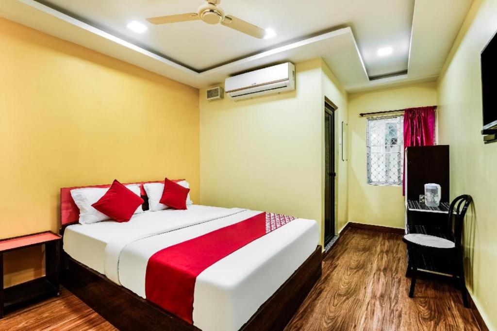 - une chambre avec un grand lit blanc et des oreillers rouges dans l'établissement HOTEL HARBOUR VIEW, à Port Blair