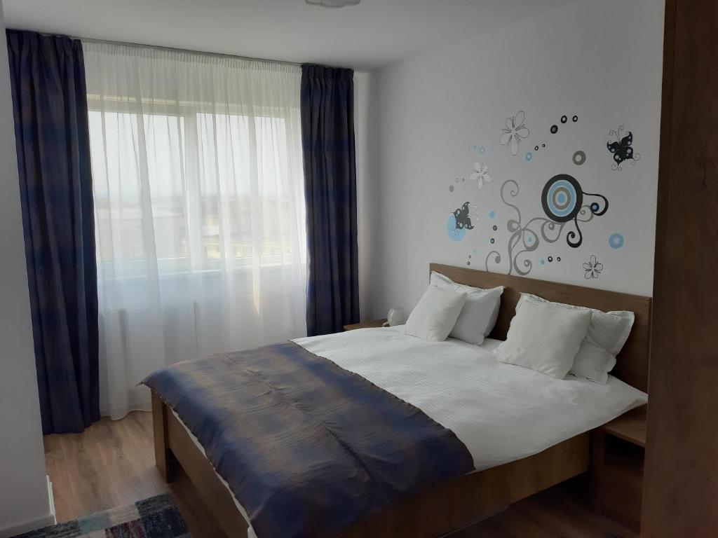 een slaapkamer met een bed en een raam bij ConfortMax in Baia Mare