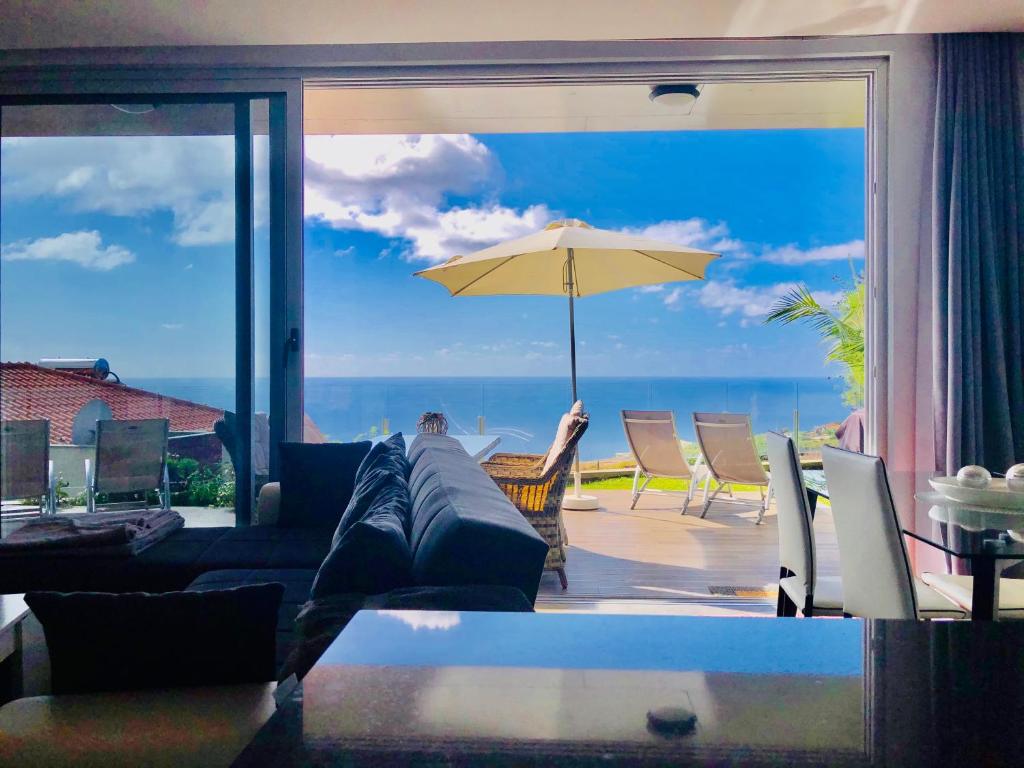 a living room with a couch and an umbrella at Villa Pinheira II in Estreito da Calheta