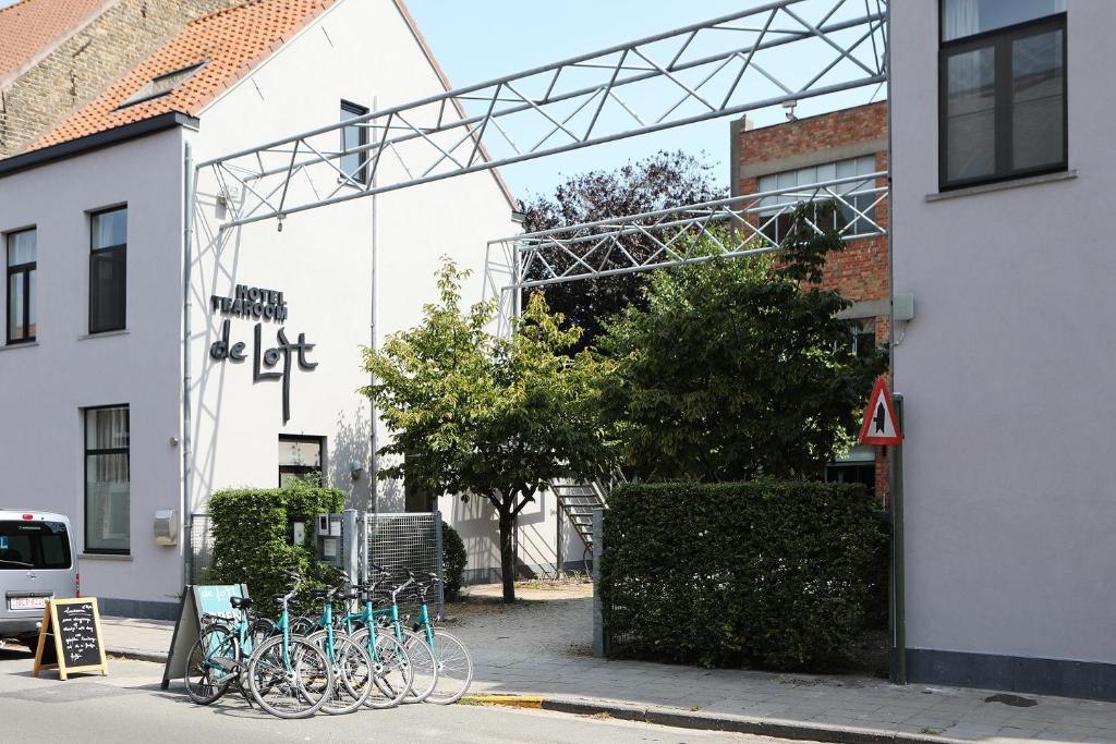 un groupe de vélos garés à l'extérieur d'un bâtiment dans l'établissement Hotel De Loft, à Furnes