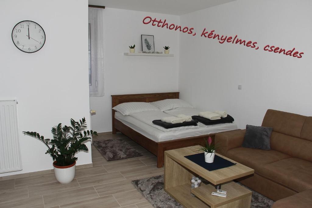 ein Wohnzimmer mit einem Bett und einem Sofa in der Unterkunft Vadvirág Apartman in Veszprém