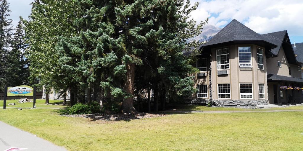 a large house with trees in front of it at Mountain View Inn in Canmore
