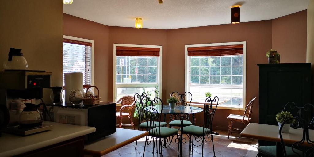 a kitchen with a table and chairs and windows at Mountain View Inn in Canmore