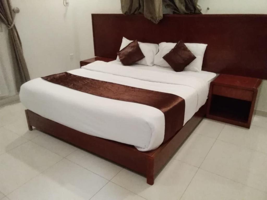 a bedroom with a large bed with a wooden headboard at Iwan Alandalusia Al Ajaweed in Jeddah