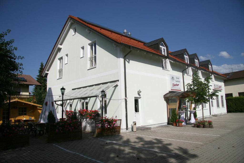 un edificio blanco con techo rojo en Hotel-Gasthof Eberherr, en Forstinning