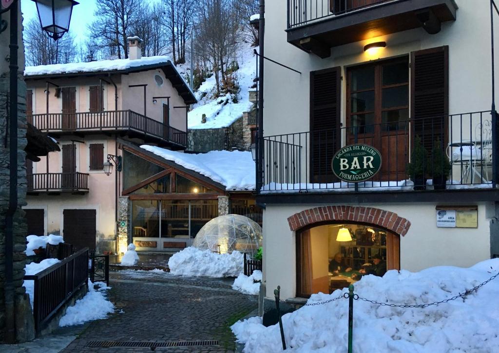 un edificio con la neve sul lato di B&B Locanda Del Mulino a Pamparato