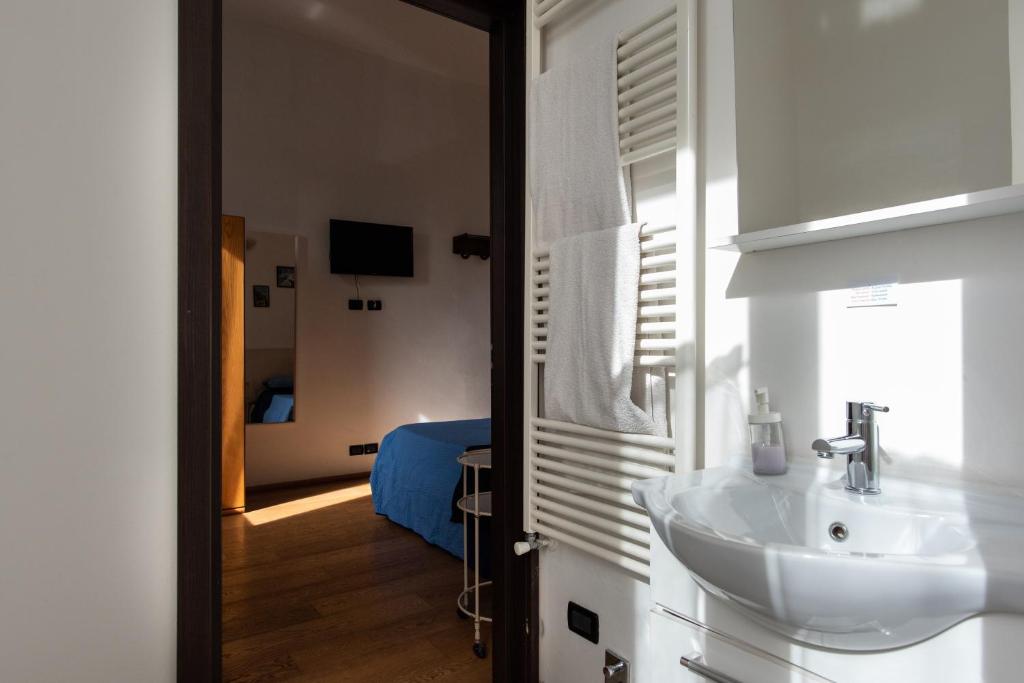 baño con lavabo y habitación con cama en Da Linda, en Livorno