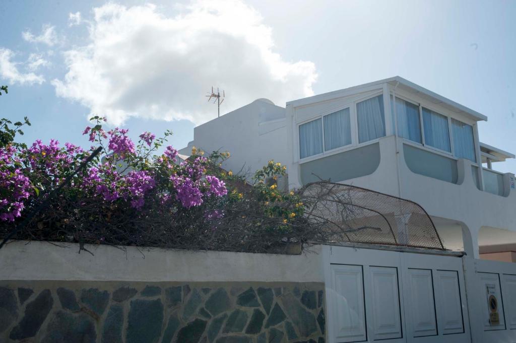 een wit huis met paarse bloemen op een muur bij Playa de Las Americas Luxury Home in Playa de las Americas