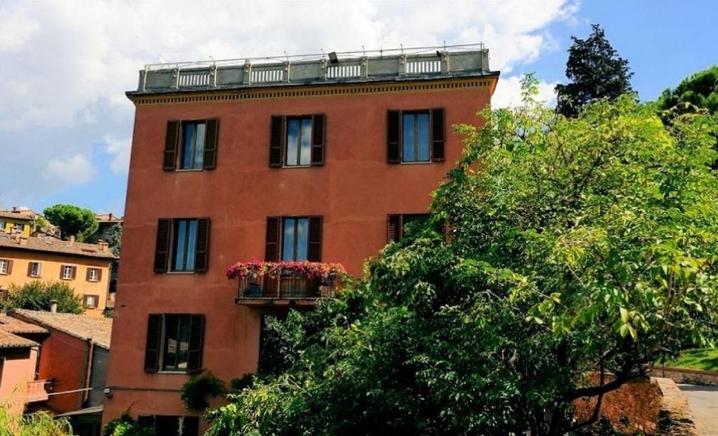 a tall red brick building with a balcony at Hotel San Sebastiano in Perugia