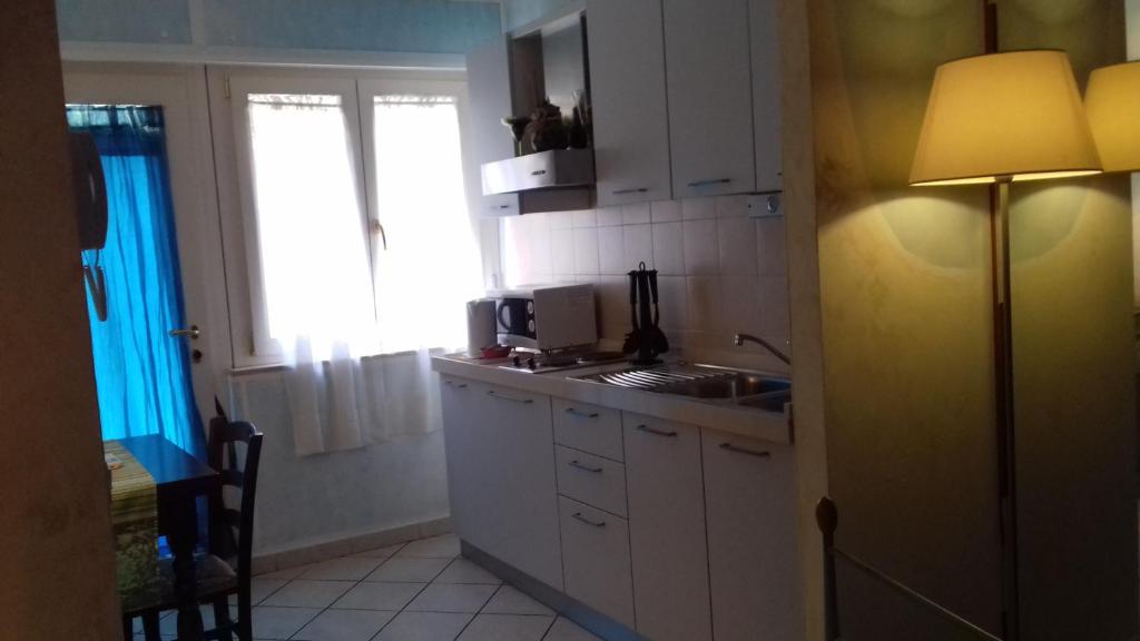 eine Küche mit einer Spüle und einer Theke mit einer Lampe in der Unterkunft La Casa di Ulisse B&B in Quercianella