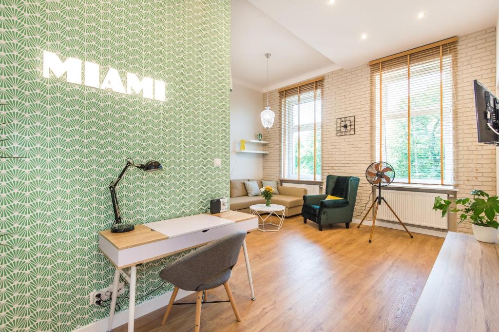 een kantoor met een groene muur met een mannenbord erop bij Bliss Apartments in Poznań