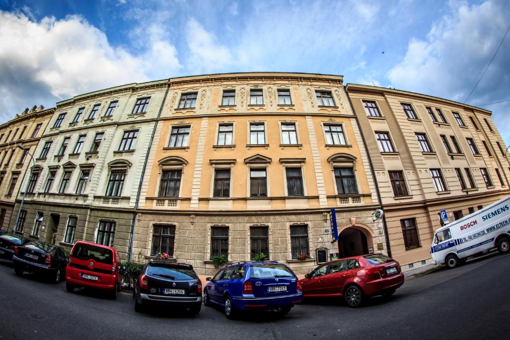 een groot gebouw met auto's geparkeerd voor het bij Hotel Pyramida in Brno
