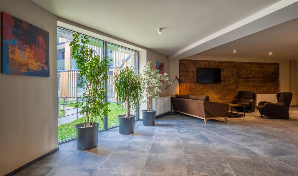 a living room with a couch and some plants at NEW GUDAURI ATRIUM 336 in Gudauri