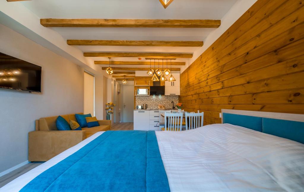 a bedroom with a large bed and a kitchen at NEW GUDAURI ATRIUM 336 in Gudauri