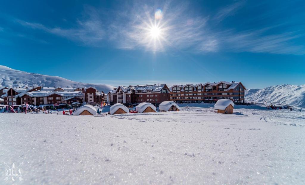 a resort in the snow with the sun in the sky at NEW GUDAURI ATRIUM 336 in Gudauri