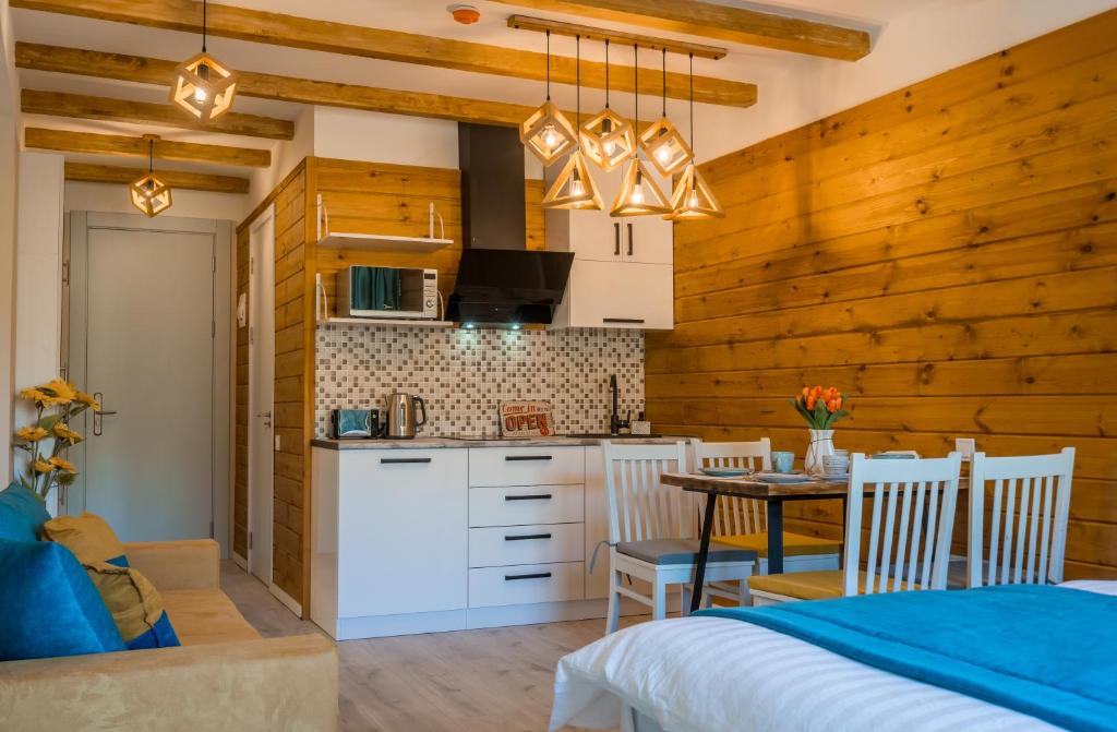 a kitchen and dining room with wooden walls and a table at NEW GUDAURI ATRIUM 336 in Gudauri