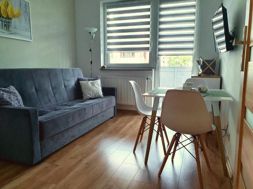 een woonkamer met een bank en een tafel bij GM Apartament Szczecin in Szczecin