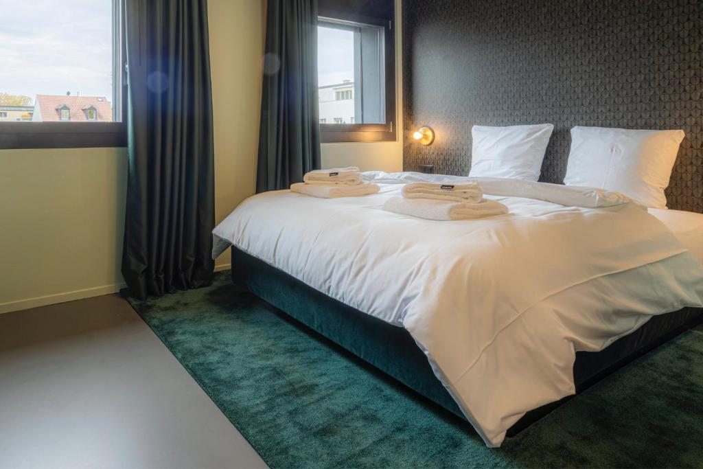 a bedroom with a large bed with towels on it at BLOOM Boutique Hotel & Lounge Basel in Basel