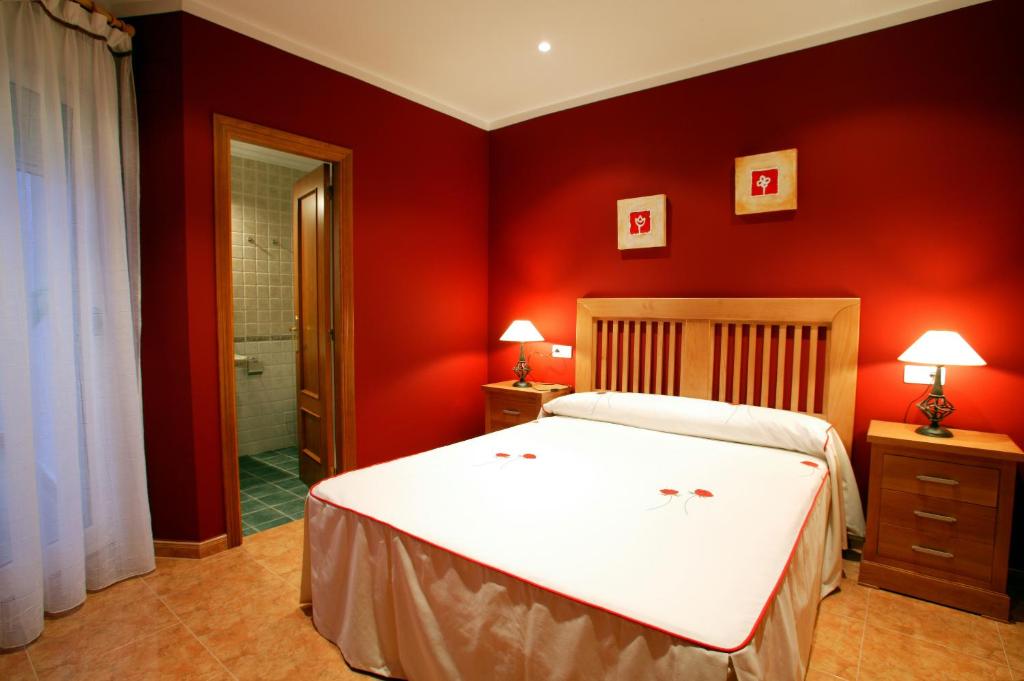 a bedroom with a white bed and red walls at APARTAMENTOS HOTEL 77 in Ayora