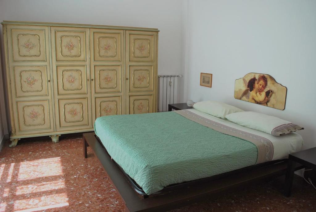 a bedroom with a bed with a painting on the wall at A Casa di Pe' Casa Vacanze in Rome