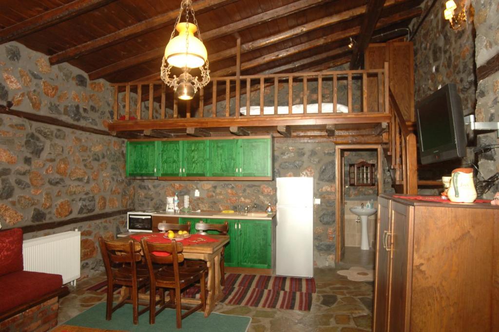 a kitchen with green cabinets and a table with chairs at Traditional Villas in Old Agios Athanasios in Palaios Agios Athanasios