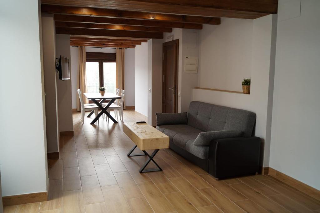 a living room with a couch and a table at Puente viejo de Buitrago CASA ENCINA in Buitrago del Lozoya