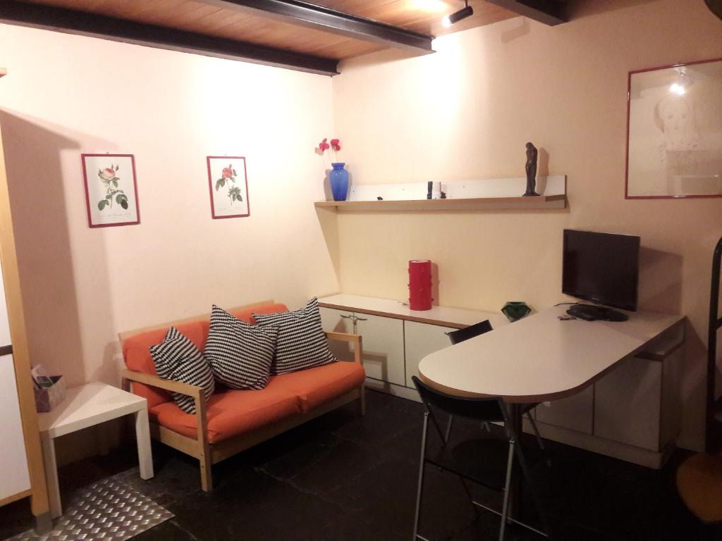 Zimmer mit Sofa, Tisch und Schreibtisch in der Unterkunft Suite Pantano5 in Mailand