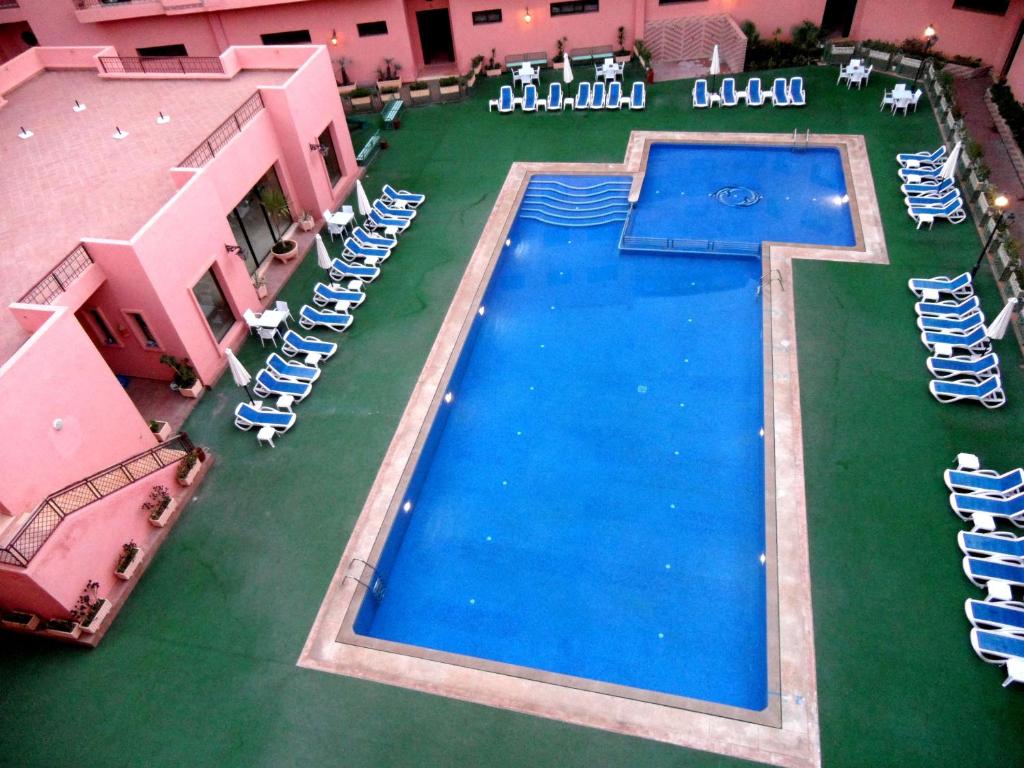 an overhead view of a large swimming pool with lounge chairs at Illina & Hamza Apartment in Marrakesh