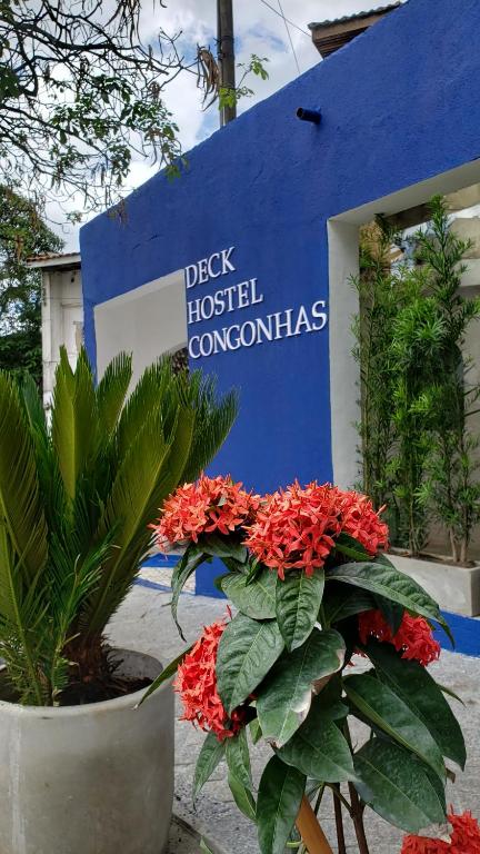 Um sinal para um hospital com flores vermelhas à frente. em Deck Hostel Congonhas em São Paulo