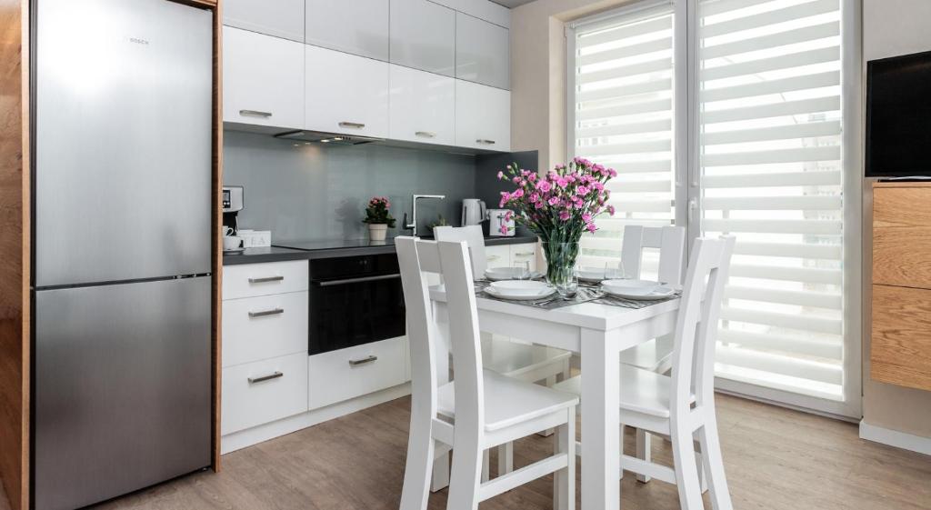 eine Küche mit einem weißen Tisch und weißen Schränken in der Unterkunft Ariańska 6 Apartments by LET'S KRAKOW in Krakau