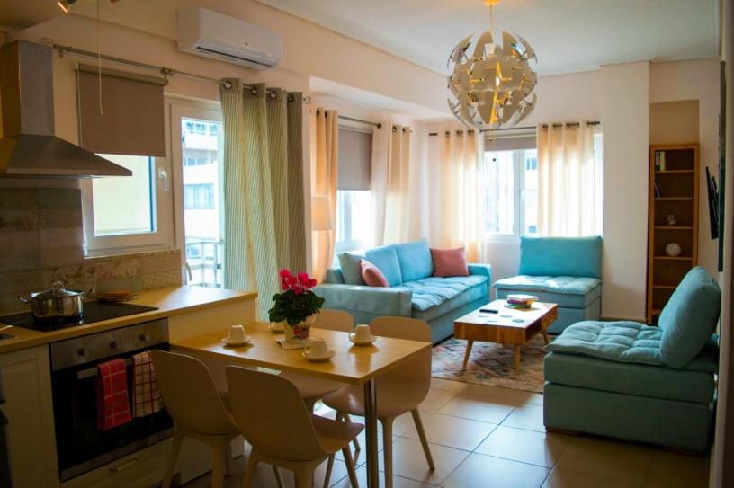 een keuken en een woonkamer met een tafel en stoelen bij SUNNY CENTRAL LUXURY APARTMENT in Volos