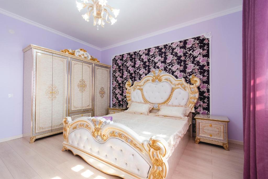 um quarto com uma cama dourada e branca e uma cómoda em Razmestim в ЖК Шахристан на 15 этаже em Almaty