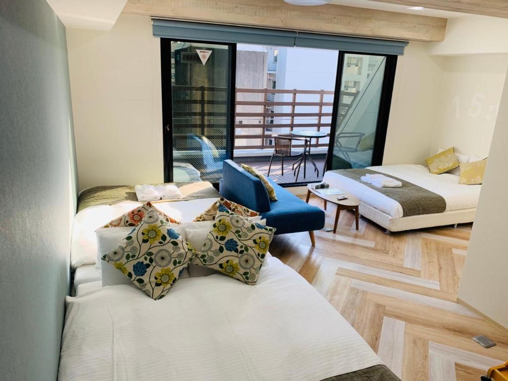 un salon avec deux lits et un canapé dans l'établissement WELLSTAY Honmachi, à Osaka