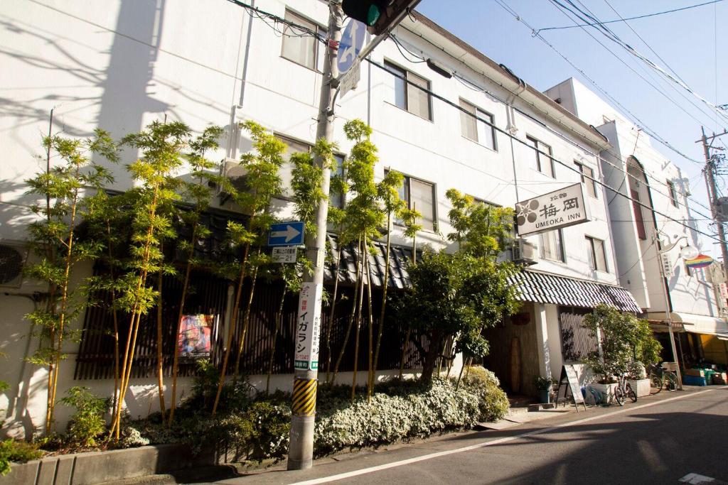 un edificio con plantas al lado de una calle en Umeoka Ryokan, en Nagano