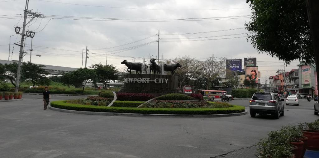 a statue of two horses on a city street at 101 Newport Boulevard in Manila
