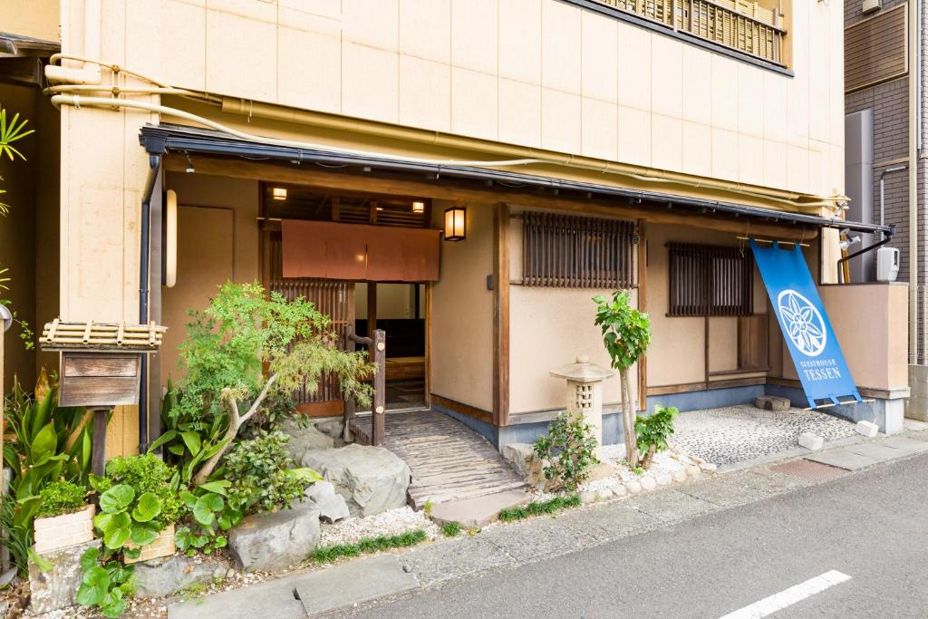 a building with a blue flag in front of it at Tessen Guesthouse in Shizuoka