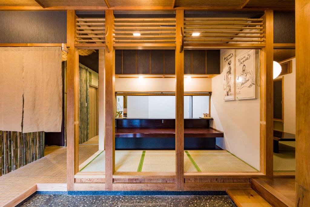 a room with glass doors and wooden floors at Tessen Guesthouse in Shizuoka