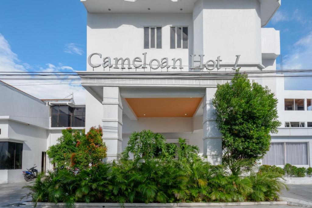 RedDoorz Plus @ Cameloan Hotel Palu في بالو: مبنى ابيض مكتوب عليه المستشفى الكندي