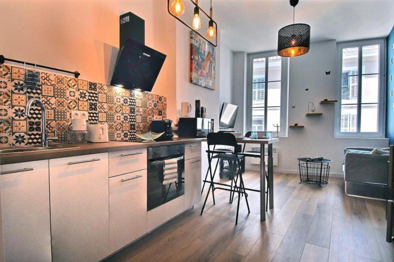 a kitchen with a counter and a table with chairs at APPARTEMENT NEUF HYPER CENTRE _ SAINT FERREOL in Marseille