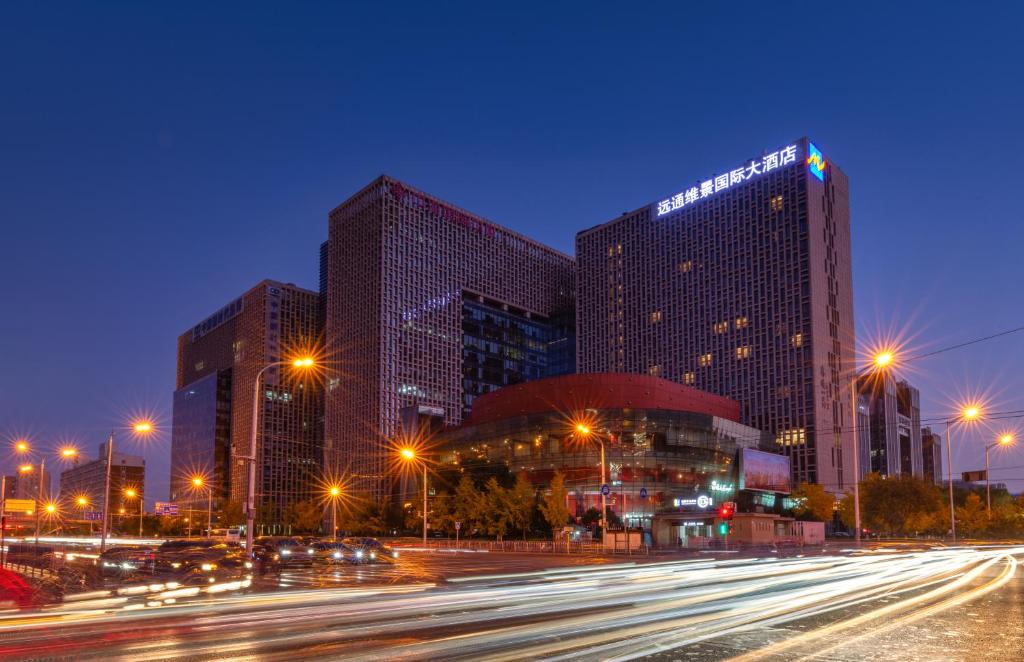 una ciudad con edificios altos y luces de la calle por la noche en Grand Metropark Yuantong Hotel Beijing, en Beijing