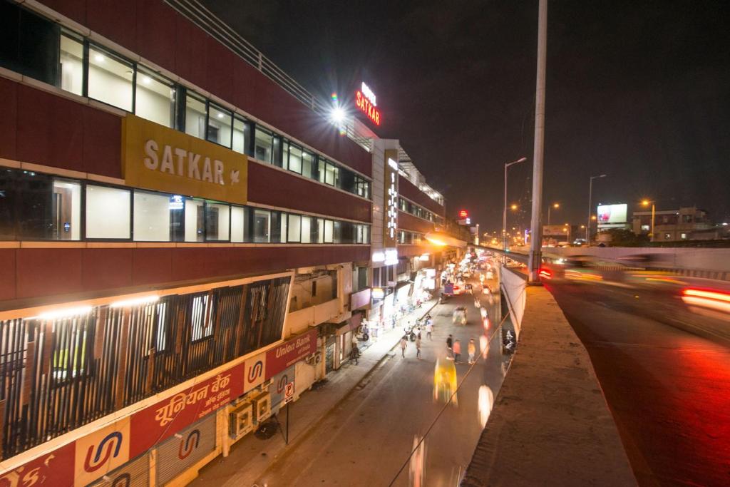 una strada trafficata di notte con le auto di Hotel Satkar a Surat
